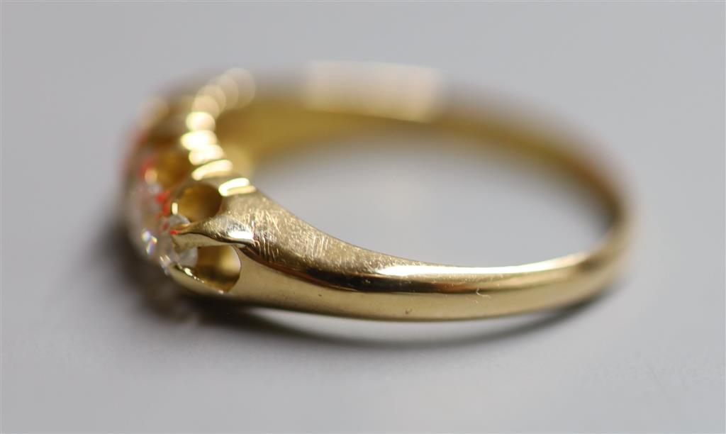 An early 20th century 18ct gold and graduated five stone diamond set half hoop ring, size P, gross 4 grams.